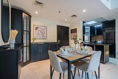 a kitchen and dining room with a table and chairs at Stunning 1 BR Apartment with Pool View in JVC Dubai in Dubai