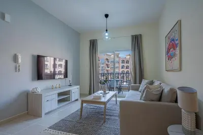 a living room with a couch and a table at Stunning 1 BR Apartment with Pool View in JVC Dubai in Dubai