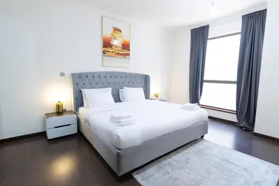 a bedroom with a large white bed and a window at MURJAN JBR Apartments by HAPPY SEASON in Dubai