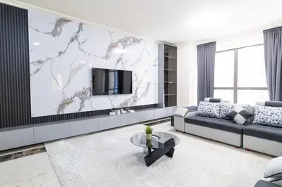 a living room with a couch and a tv on a wall at MURJAN JBR Apartments by HAPPY SEASON in Dubai