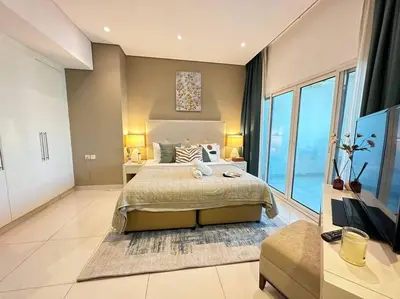 a bedroom with a large bed and a large window at Manzil - Cozy Studio nr Downtown w Canal Views in Dubai
