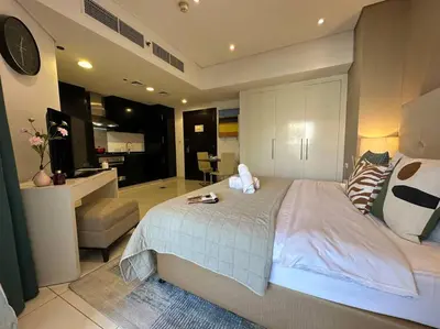 a large bedroom with a large bed and a kitchen at Manzil - Cozy Studio nr Downtown w Canal Views in Dubai