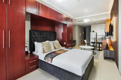 a bedroom with a large bed and a kitchen at Furnished Apartment for Rent in Saba 3, JLT in Dubai