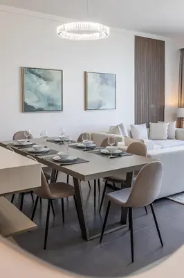 a dining room with a table and chairs and a couch at Spacious 3BDR with Maid Room I Creek Harbour I Creek Gate Tower 2 in Dubai