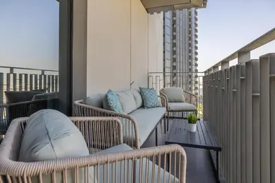 a balcony with wicker chairs and couches on a building at Spacious 3BDR with Maid Room I Creek Harbour I Creek Gate Tower 2 in Dubai
