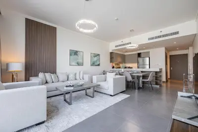 a living room with white furniture and a kitchen at Spacious 3BDR with Maid Room I Creek Harbour I Creek Gate Tower 2 in Dubai