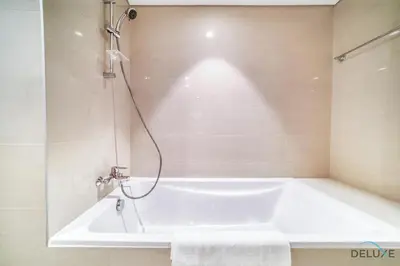 a white bath tub in a bathroom with a shower at Plush 1BR at Act One Act Two Tower 2 Downtown Dubai by Deluxe Holiday Homes in Dubai