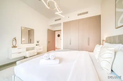 a white bedroom with a large white bed with two towels at Plush 1BR at Act One Act Two Tower 2 Downtown Dubai by Deluxe Holiday Homes in Dubai
