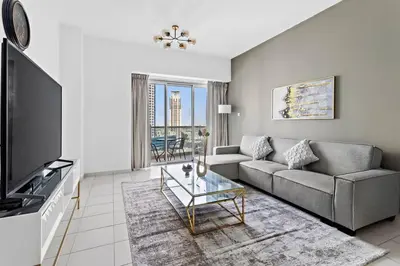 a living room with a couch and a tv at StoneTree - Marina Tower 1BR - Dubai Marina in Dubai