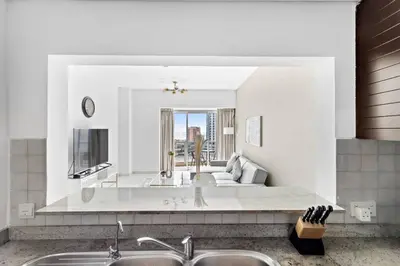 a kitchen with a living room with a couch at StoneTree - Marina Tower 1BR - Dubai Marina in Dubai