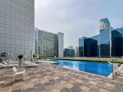 a pool on the roof of a building with buildings at Trophy - Cityscape Posh Suite in Dubai