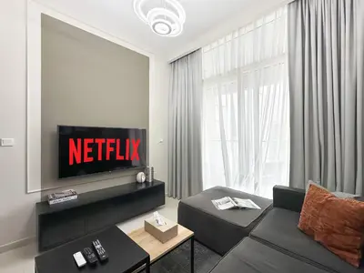 a living room with a couch and a tv at Trophy - Cityscape Posh Suite in Dubai