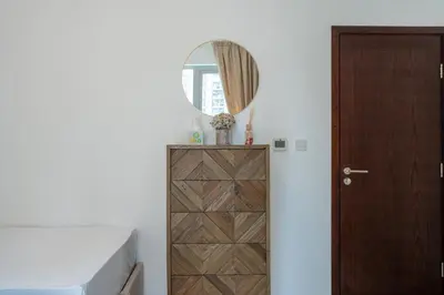 a bedroom with a wooden door and a mirror at INA HOMES - Residences Tower 1 Upper Floor in Dubai