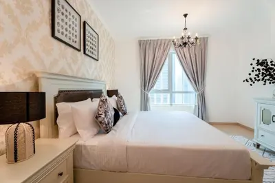 a bedroom with a bed and a chandelier at INA HOMES - Residences Tower 1 Upper Floor in Dubai