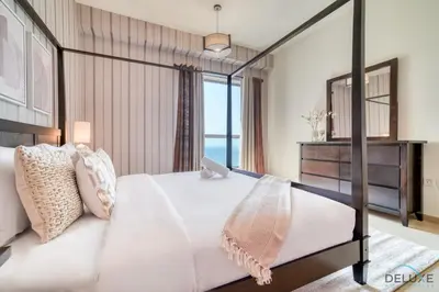 a bedroom with a bed and a large window at Pristine 2BR at Bahar 2 JBR by Deluxe Holiday Homes in Dubai