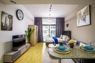 a living room with a couch and a table at Modern Silicon Oasis Studio Near Academic City in Dubai