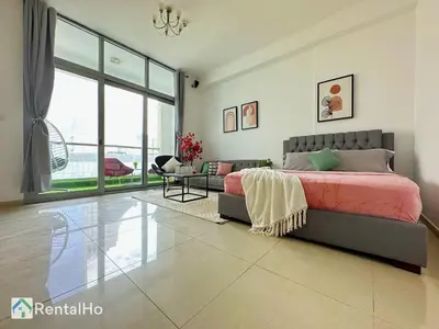 a bedroom with a bed and a living room at Big Studio w/ Balcony and easy access to the Beach in Dubai