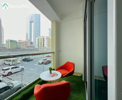 a room with a table and chairs and a view of a city at Big Studio w/ Balcony and easy access to the Beach in Dubai