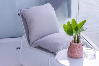 a pillow and a plant on a table at Floral Charm studio in Damac Hills by Suiteable in Dubai