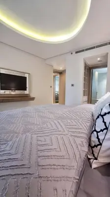 a bedroom with a large bed with a tv on the wall at Luxury Paramount Hotel Apt B327 in Dubai
