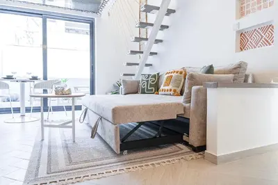 a living room with a couch and a table at Relax & Recharge Studio Loft with hanging net in Dubai