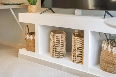 a white shelf with baskets on it in a kitchen at Relax & Recharge Studio Loft with hanging net in Dubai