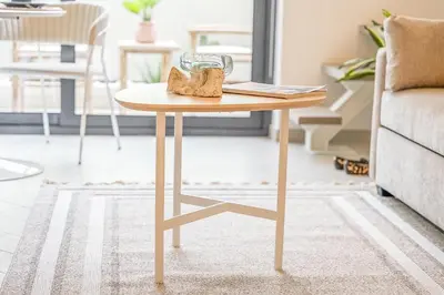 a wooden table in a living room next to a couch at Relax & Recharge Studio Loft with hanging net in Dubai