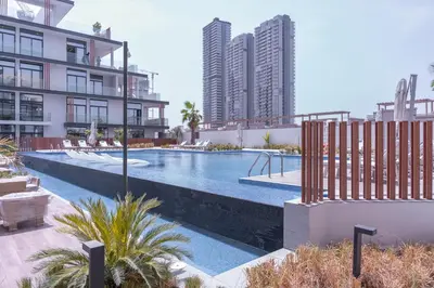 a large swimming pool in a city with tall buildings at Relax & Recharge Studio Loft with hanging net in Dubai