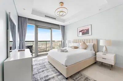 a white bedroom with a large bed and large windows at StoneTree - Paramount 3BR - Panoramic View in Dubai