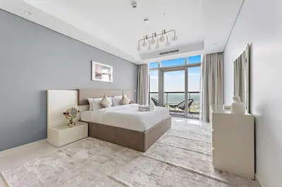 a white bedroom with a bed and a large window at StoneTree - Paramount 3BR - Panoramic View in Dubai