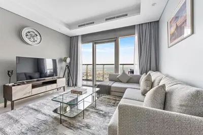 a living room with a couch and a tv at StoneTree - Paramount 3BR - Panoramic View in Dubai