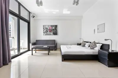 a white room with a bed and a couch at StoneTree - DEC Tower 2 Studio - Dubai Marina in Dubai