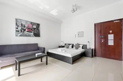 a room with a bed and a couch and a table at StoneTree - DEC Tower 2 Studio - Dubai Marina in Dubai