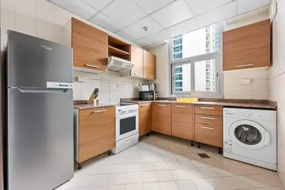 a kitchen with a washing machine and a washer at StoneTree - DEC Tower 2 Studio - Dubai Marina in Dubai