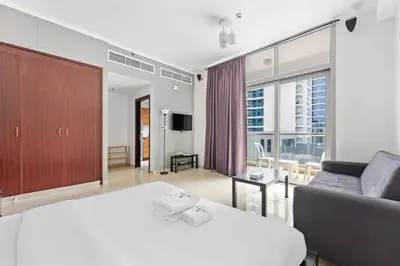 a bedroom with a large white bed and a couch at StoneTree - DEC Tower 2 Studio - Dubai Marina in Dubai