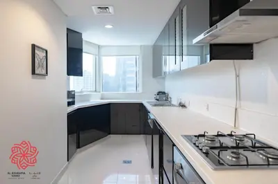 a kitchen with white counters and a stove top oven at Alashrafia Saray- Waterfront 3 BDR apartment Business Bay in Dubai