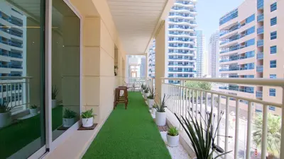 a balcony with plants and a chair on a building at Dubai Marina,JBR -Luxurious 2 BR King Suite in Dubai