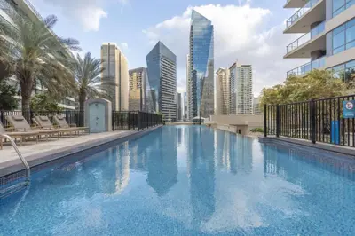 a swimming pool with a city skyline in the background at Maison Privee - Dreamy Apt with Jaw-Dropping Marina Views in Dubai