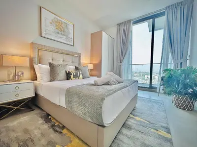 a bedroom with a large bed and a large window at Modern 1 BR Apartment at JVC Dubai Prime Location! in Dubai