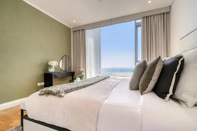 a bedroom with a large white bed with a large window at Bluewaters Residences - Sea View, Bluewaters Island - Mint Stay in Dubai