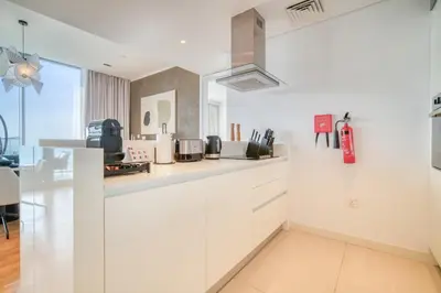 a kitchen with white cabinets and a counter top at Bluewaters Residences - Sea View, Bluewaters Island - Mint Stay in Dubai