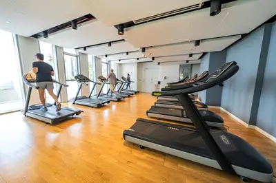 a group of people exercising on treadmills in a gym at Bluewaters Residences - Sea View, Bluewaters Island - Mint Stay in Dubai
