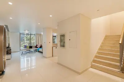 a living room with a staircase in a house at Chic 2BR Duplex, Huge Balcony High-End Furniture - Allsopp&Allsopp in Dubai