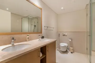 a bathroom with two sinks and a mirror and a toilet at Chic 2BR Duplex, Huge Balcony High-End Furniture - Allsopp&Allsopp in Dubai