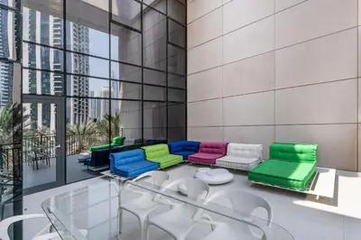 a room with colorful chairs and tables in a building at Chic 2BR Duplex, Huge Balcony High-End Furniture - Allsopp&Allsopp in Dubai