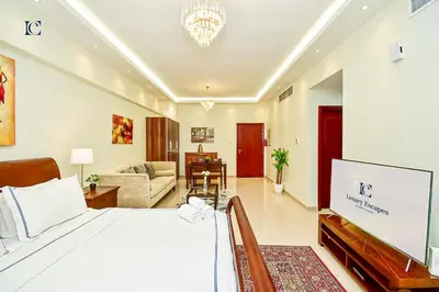 a bedroom with a bed and a living room at Luxury Escapes - Modern Studio Apt - Steps to Metro, Marina Mall and JBR Beach - Marina Pearl in Dubai