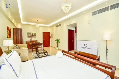 a bedroom with a bed and a living room at Luxury Escapes - Modern Studio Apt - Steps to Metro, Marina Mall and JBR Beach - Marina Pearl in Dubai