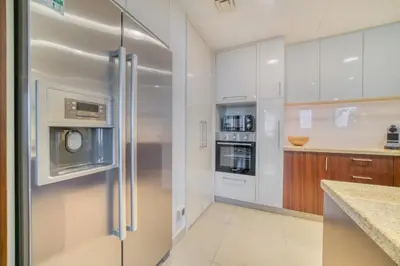 a kitchen with a stainless steel refrigerator with a microwave at Burj Vista Tower 1 - City View, Downtown Dubai - Mint Stay in Dubai