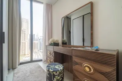 a bathroom with a dresser with a mirror and a window at Frank Porter - The Address JBR in Dubai