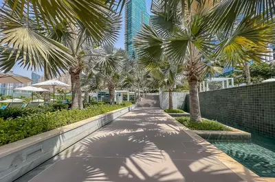 a walkway with palm trees in a resort at Frank Porter - The Address JBR in Dubai